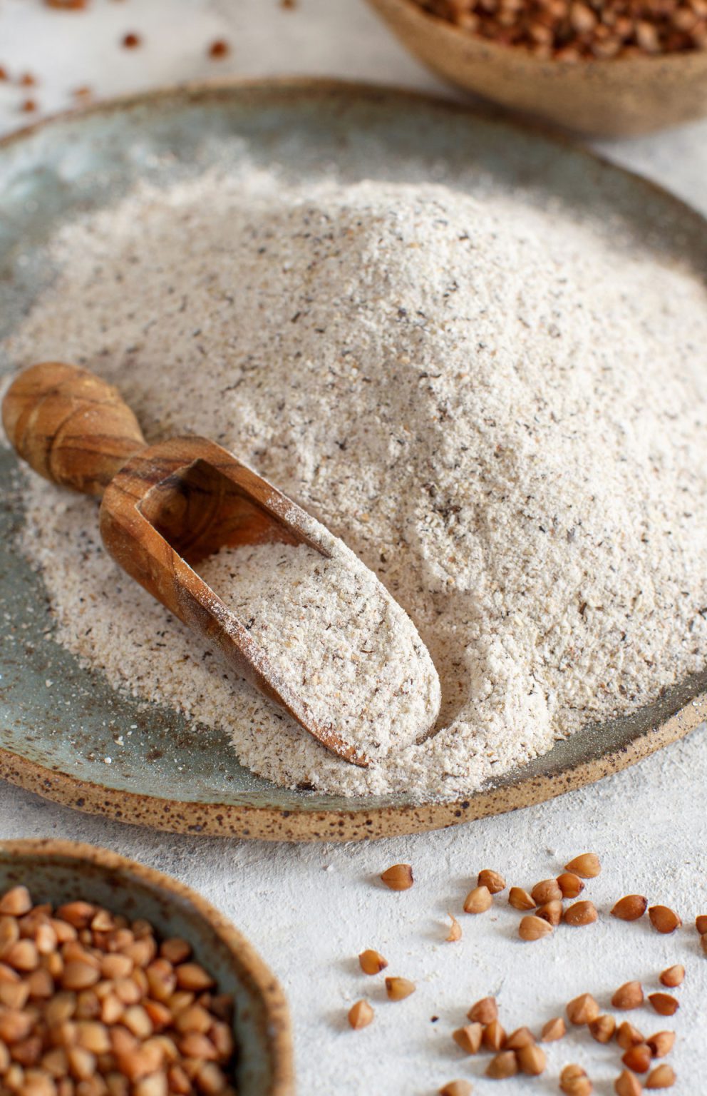 buckwheat flour in a bowl and buckwheat grain in a