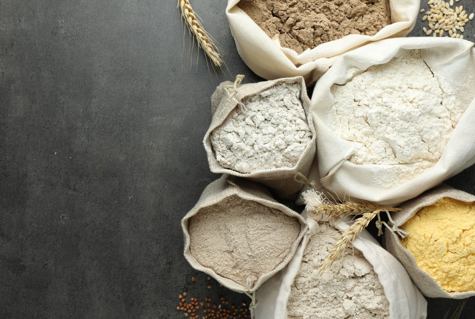 different types of flour in bags on grey table fl